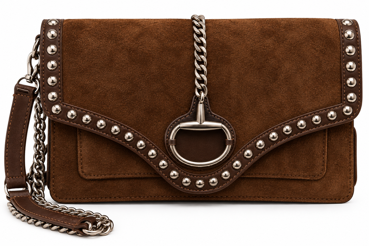 A brown suede shoulder bag with silver-tone hardware, featuring a horsebit-shaped turn-lock closure, studded leather trim, and a chain strap on a white background.